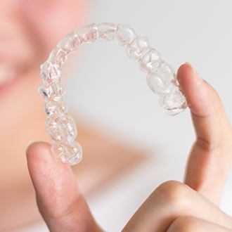 Hand holding a clear aligner tray
