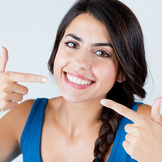 Woman pointing to her aligned smile