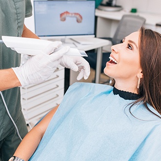 Orthodontist taking impressions of female patient's teeth