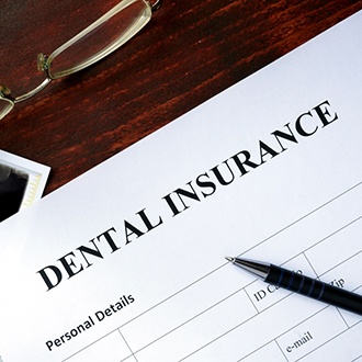 Dental insurance paperwork on desk with X-ray