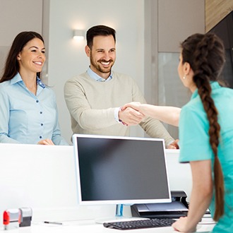 Patient and dental receptionist shaking hands