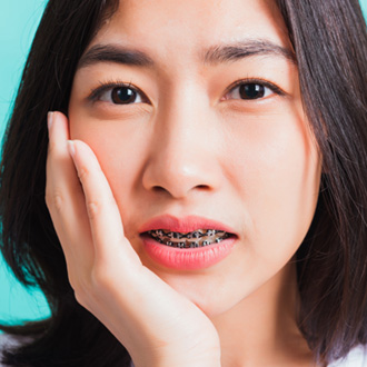 a patient with braces dealing with oral pain