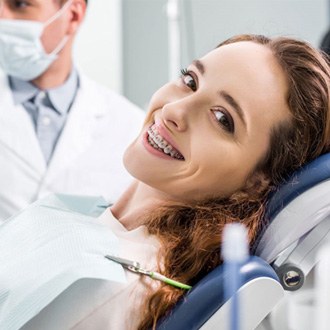 a patient with braces smiling at the orthodontist