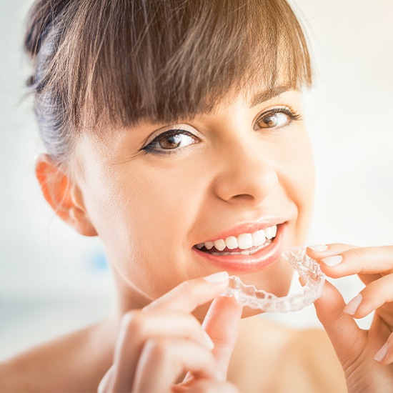 Woman placing an Invisalign tray