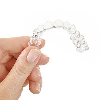 Hand holding an Invisalign tray