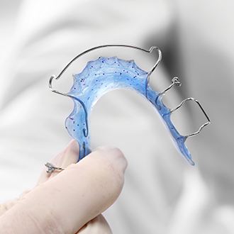 Hand holing a pediatric orthodontic appliance