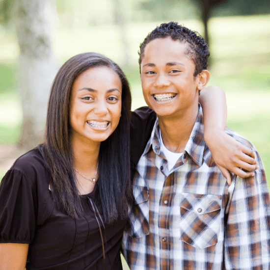 Two smiling teens receiving orthodontic services in Milton
