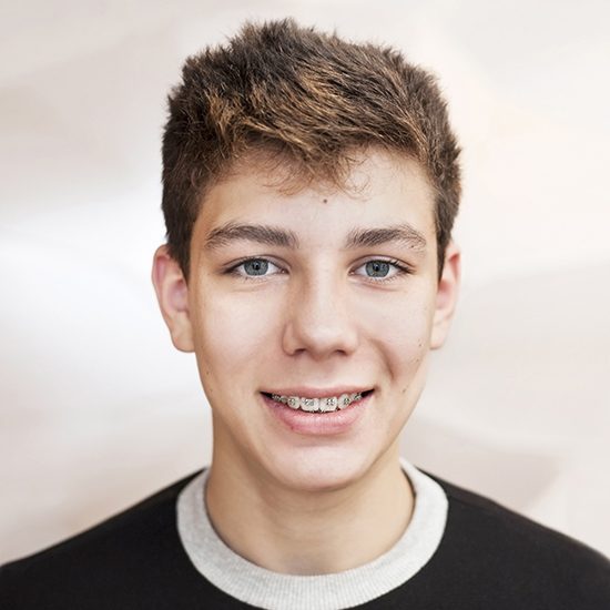 Smiling teen with traditional braces in Milton Massachusetts