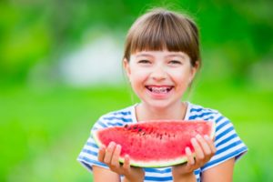 Girl with watermelon and braces in summer