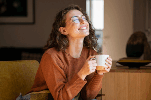 an Invisalign patient holding a cup of coffee